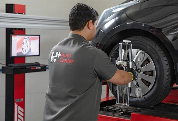 imagem de mecanico segurando um pneu de carro no chão